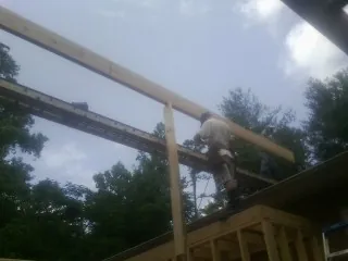 Carpenter setting a ridge beam over a new addition frame — Ice Dam Removal by Roofing Brothers in Poughkeepsie