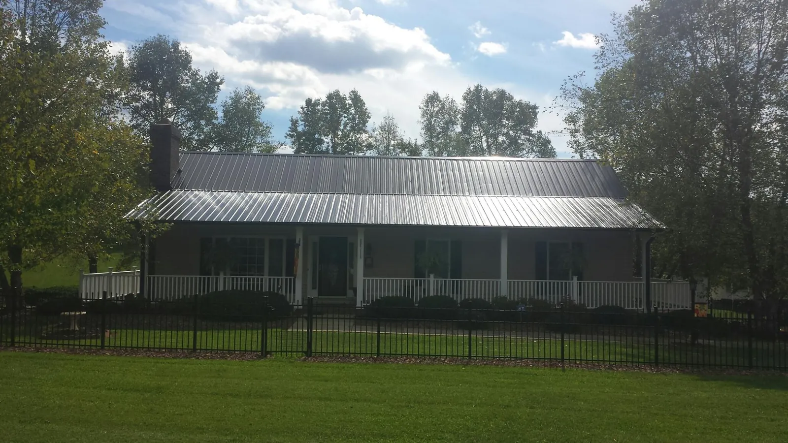 Gray metal roof on a brick ranch with a full width front porch — Gutter Guard Installation work by our crew in Poughkeepsie
