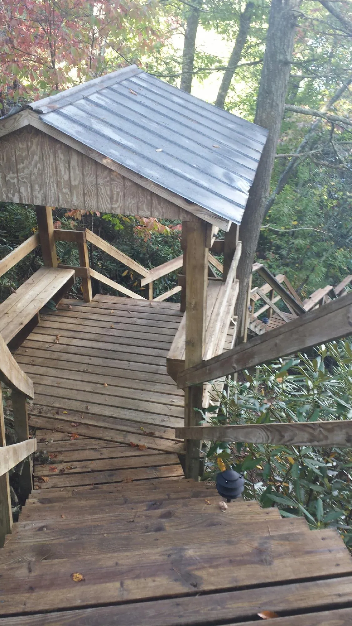 Metal roofed shelter over wooden steps on a wooded walkway — Skylight Repair & Installation work by our crew in Poughkeepsie