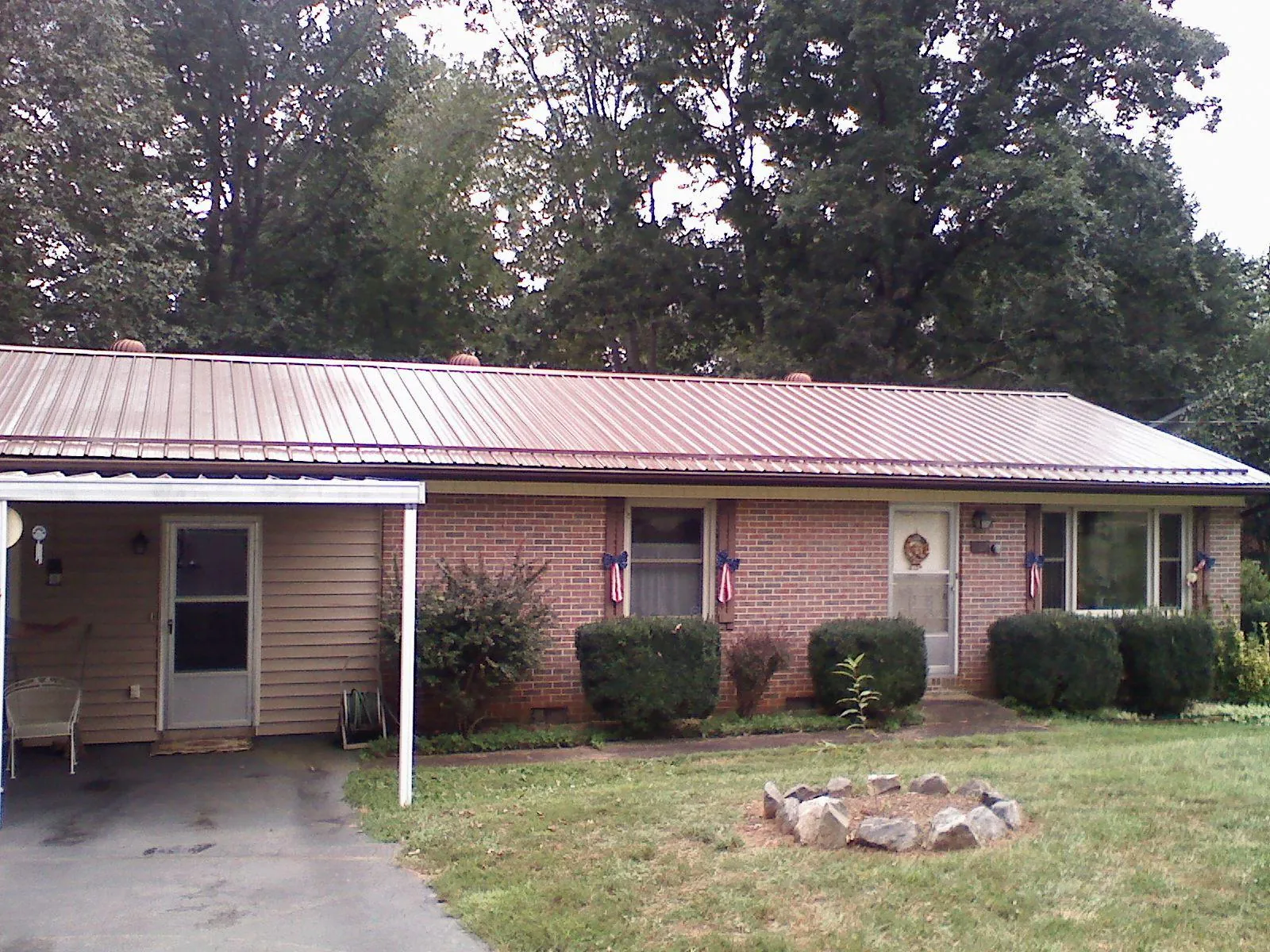 Bronze metal roof and carport on a brick ranch home — Roof Repair work by our crew in Poughkeepsie